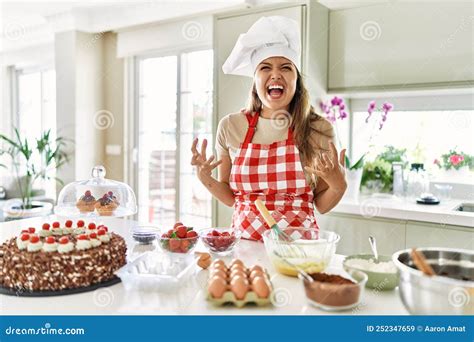 Beautiful Young Brunette Pastry Chef Woman Cooking Pastries At The Kitchen Crazy And Mad