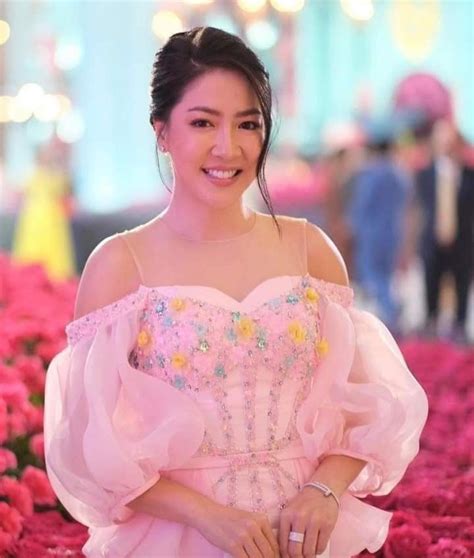 A Woman In A Pink Dress Posing For The Camera With Flowers All Over Her