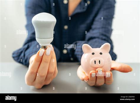 Female Hand Holding A Light Bulb Above The Table Stock Photo Alamy