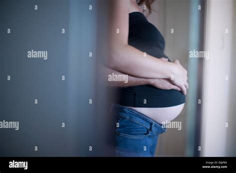 Husband Wrapping Arms Around Pregnant Wife Side View Stock Photo Alamy