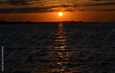 Sol cayendo detras de las montañas sobre el mar mediterraneo Stock