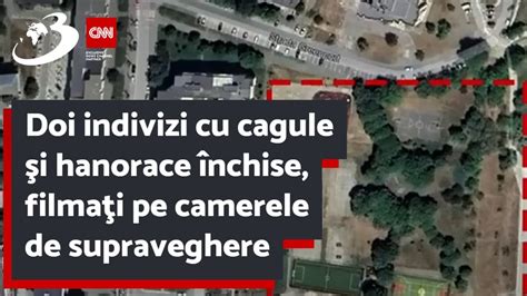 Doi indivizi cu cagule şi hanorace închise filmaţi pe camerele de