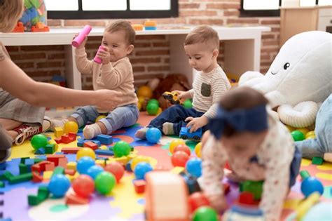 Grupo de niños pequeños jugando con juguetes sentados en el suelo en el