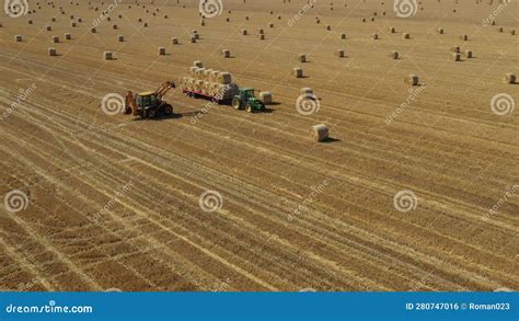 Aerial View Of Agricultural Field Collecting Round Bales Of Straw