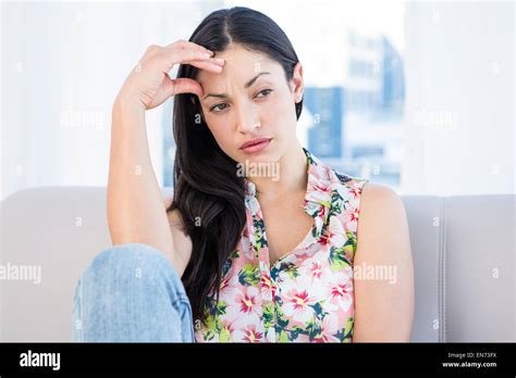 Pretty Brunette Thinking On Couch Stock Photo Alamy