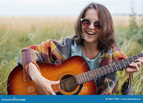 Happy Female Learning Playing Guitar While Sitting At Greenland Having