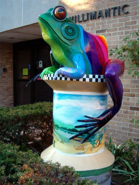 A Colorful Frog Statue Sitting On Top Of A Planter