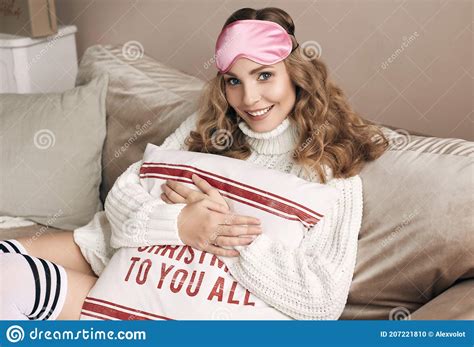 Gorgeous Blonde Woman In White Woolen Sweater And Eyemask Stock Photo