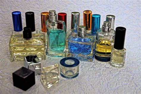 A Set Of Glass Colored Bottles With Perfume On A Gray Surface Stock