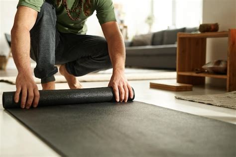 Premium Photo Closeup Of Young Man Using Mat For Yoga Exercises In