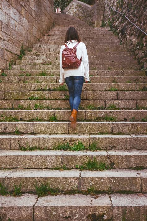 Back View Of Woman Walking Up The Stairs Of Medieval Village Of Besalu