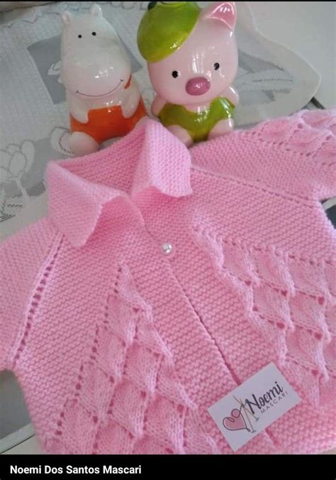 A Pink Knitted Sweater With A Pig Figurine Next To It