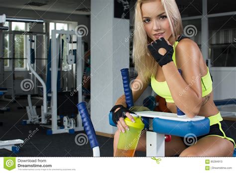 Femme Blonde Sexy Active Dans Les Vêtements De Sport Se Reposant Sur L équipement De Sport