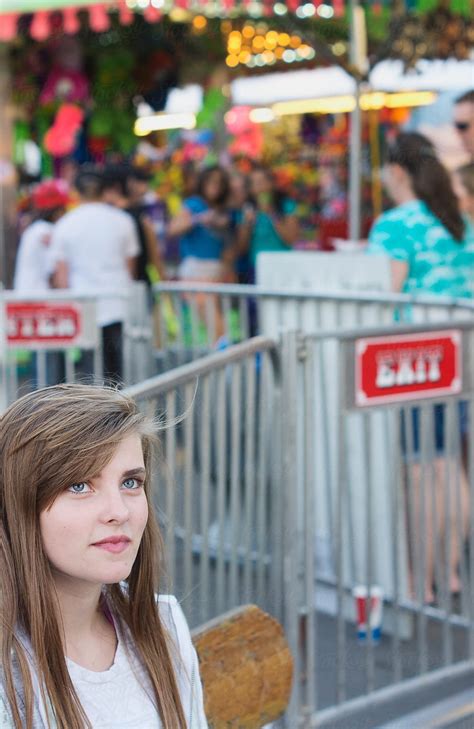 Teenager Sits On A Bench Next To The Exit Of A Ride At A Carnival By Stocksy Contributor Tana