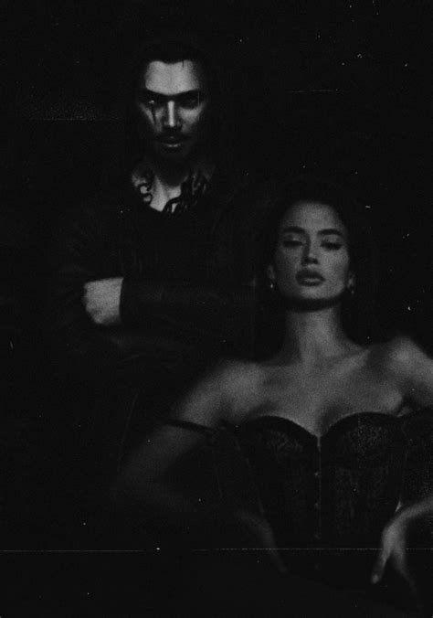 A Man Standing Next To A Woman In A Dark Room