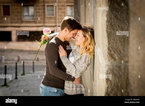 Candid Portrait Of Beautiful European Couple With Rose In Love Kissing