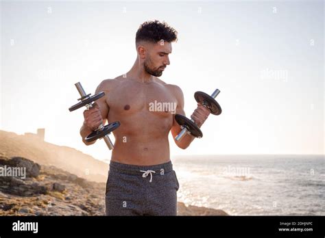 Handsome Male Athlete With Naked Torso Doing Exercises With Dumbbells