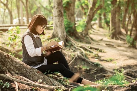 Premium Photo Woman Reading Book While Sitting In Forest