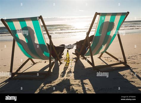 African American Couple In Love Sitting In Deckchairs Holding Hands On