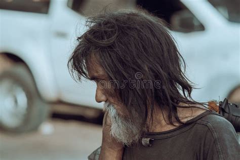 Shallow Focus Of A Male Beggar With Long Unkempt Hair And A Beard In A