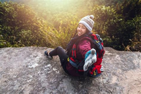 Premium Photo Portrait Of Woman Gesturing While Sitting On Rock Formation