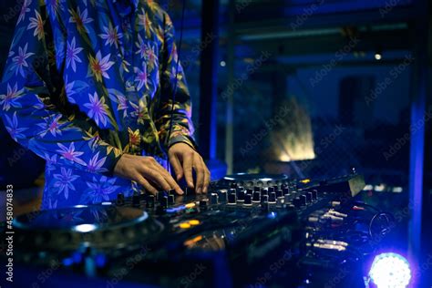 Techno Dj Playing Musical Tracks On Stage In Blue Neon Lights