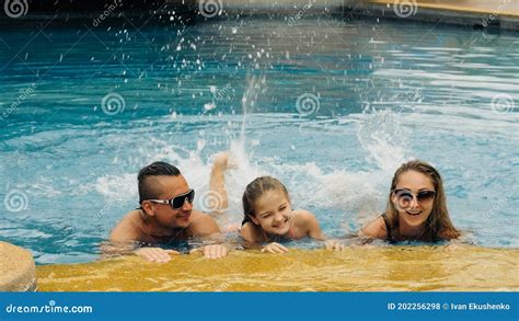 The Mother And Father With Little Daughter Have Fun In The Pool Mom And Dad Plays With The