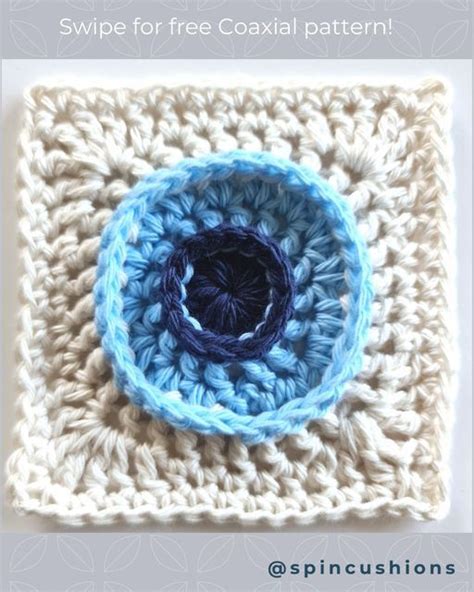 A Crocheted Square With A Blue Circle In The Center And Text That Reads