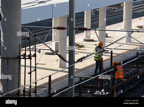 Chinese Migrant Workers Mount Electrified Devices At The Construction