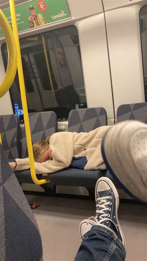 A Person Sleeping On A Train With Their Feet Up