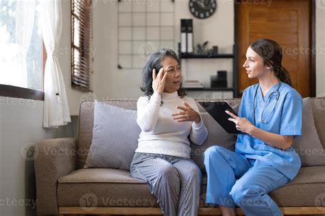 Asian Nurse Showing Health Checkup Report To Grandmather And Giving