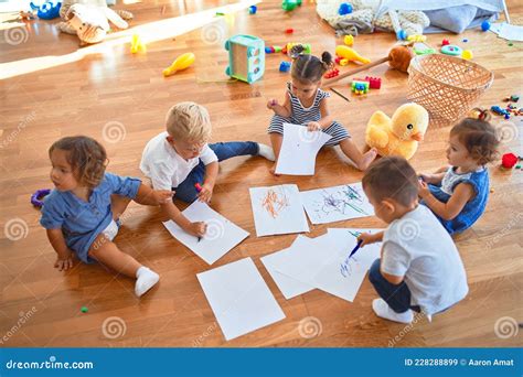 Adorable Grupo De Niños Sentados En El Suelo Dibujando Con Papel Y