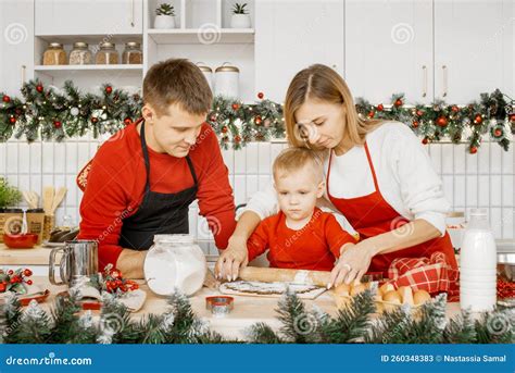 Feliz Familia Desplegando Masa Para Hornear Galletas De Navidad En La