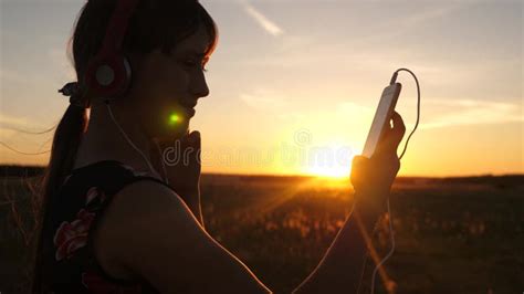 Menina Feliz Que Escuta A M Sica Em Um Smartphone Nos Raios De Um Por