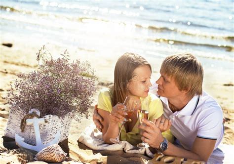 Los Pares Jovenes Felices Que Disfrutan De Comida Campestre En La Playa