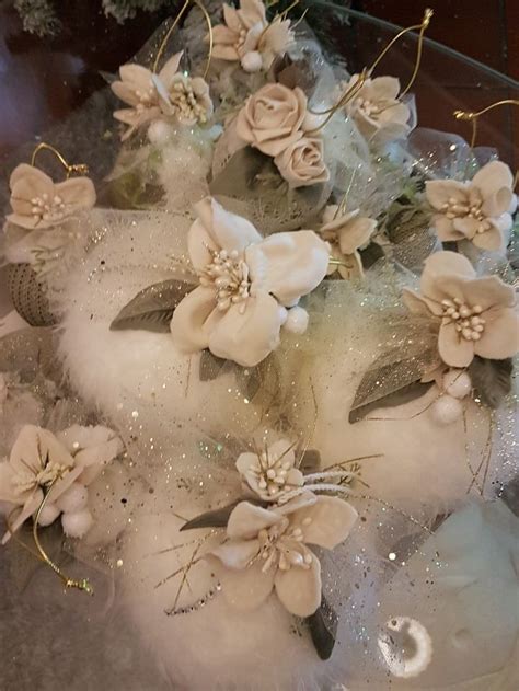 A Cake With White Flowers And Feathers On It S Side Sitting On A Table