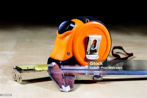 ukur  mengukur jarak sebuah ukuran tergeletak  atas meja kayu