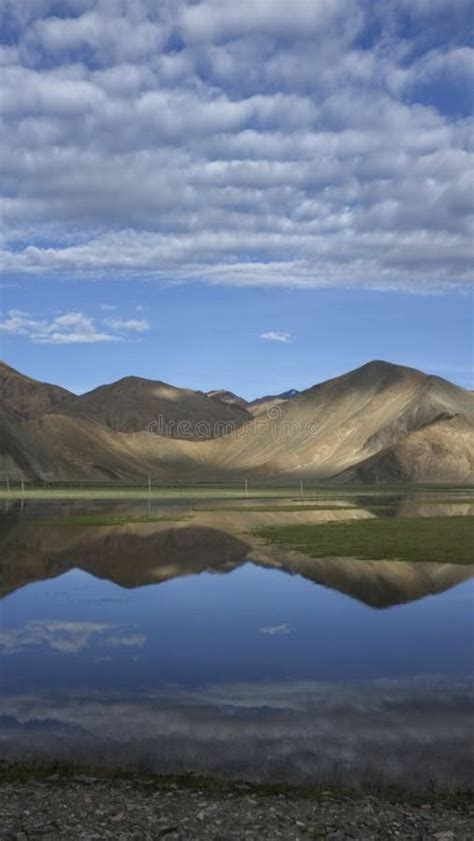 The Calm And Beautiful Lake At The Foot Of The Mountain Reflects The