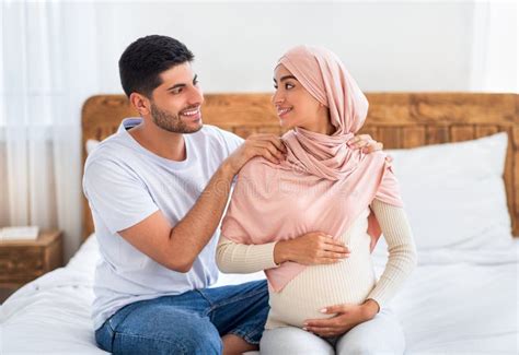 Massage During Pregnancy Concept Considerate Black Guy Massaging His Wife`s Shoulders On Comfy