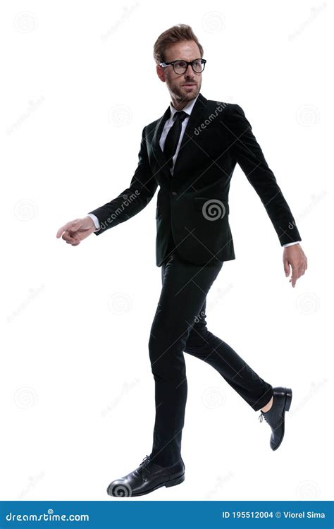 Elegant Man In Black Suit Looking To Side And Walking Stock Photo