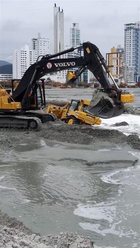 Vídeo mostra máquina sendo engolida pela areia durante obra de