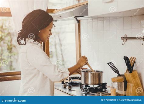 African American Black Woman Cooking Boiling Soup In The Kitchen At