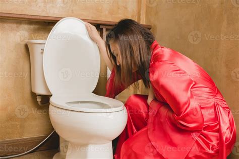 A Woman In A Red Nightgown Vomiting In The Bathroom 17015761 Stock