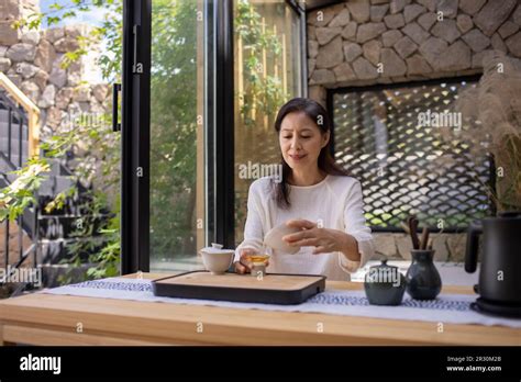 Elegant Mature Chinese Woman Drinking Tea In Tea Room Stock Photo Alamy