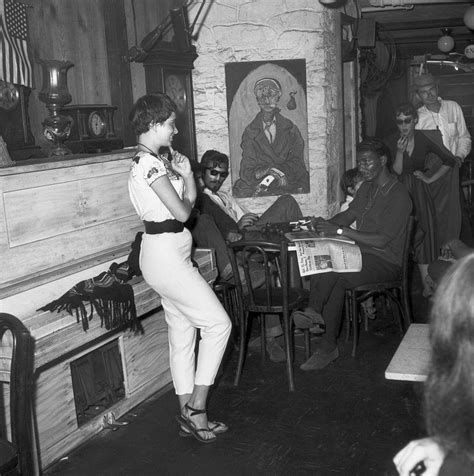 A beatnik woman stands in front of the entrance to the Gaslight Cafe, a center of beatnik poet ...