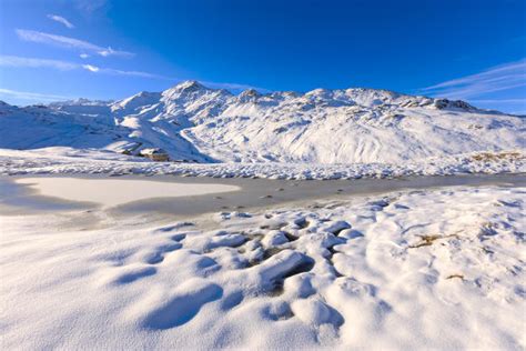 Blue Sky And Sun On Lake Piz Umbrail Surrounded By Snowy Peaks At