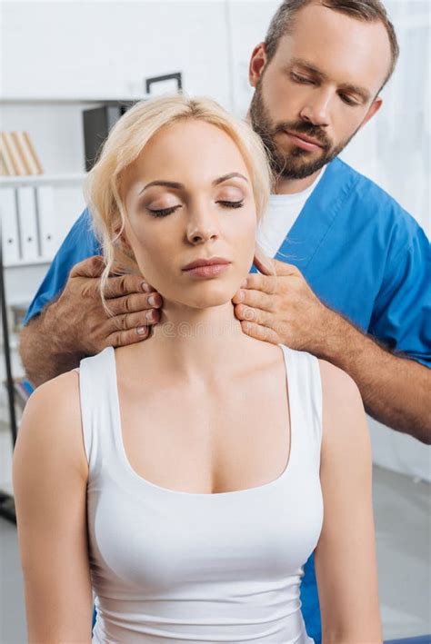 Portrait Of Massage Therapist Massaging Neck Of Young Woman Stock Image