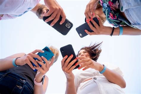 Grupo de jóvenes amigos mediante teléfono celular móvil Foto Premium