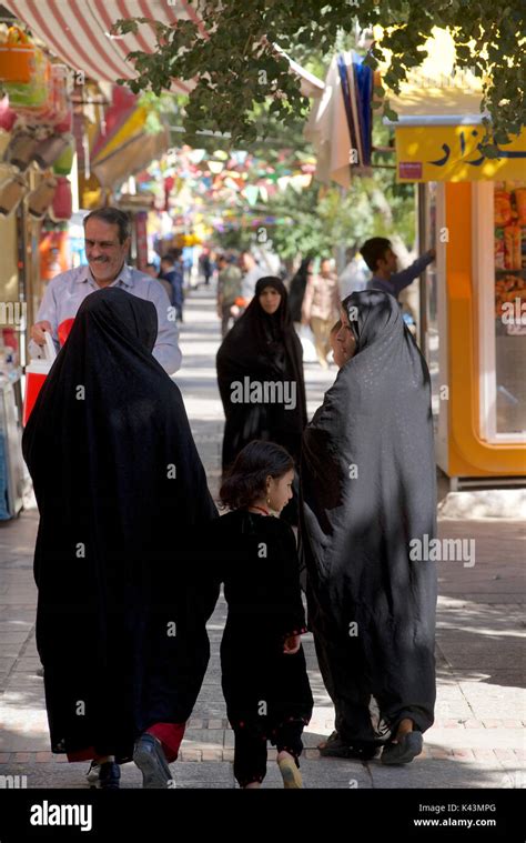 Iranian Women Wearing The Chador And Walking In The Street With