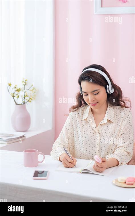 Focused Woman Wearing Headphones Write Notebook Stock Photo Alamy